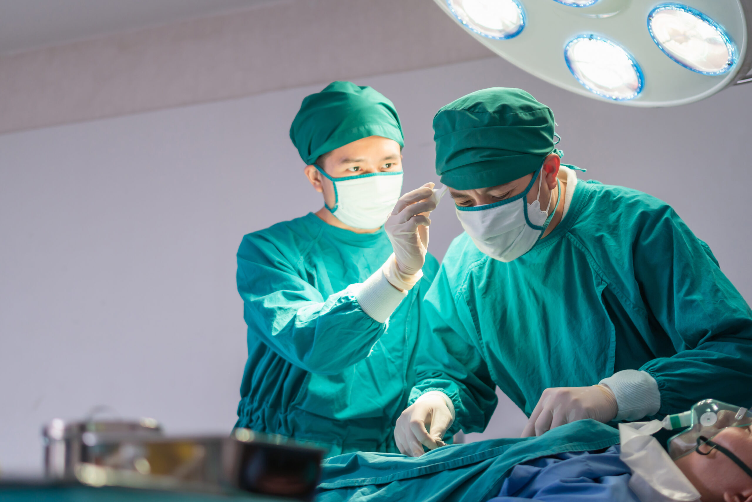 Medical team performing surgical operation in operating Room, Concentrated surgical team operating a patient